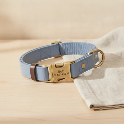 Collier pour chien en cuir bleu clair personnalise avec plaque gravee, pose sur une table en bois