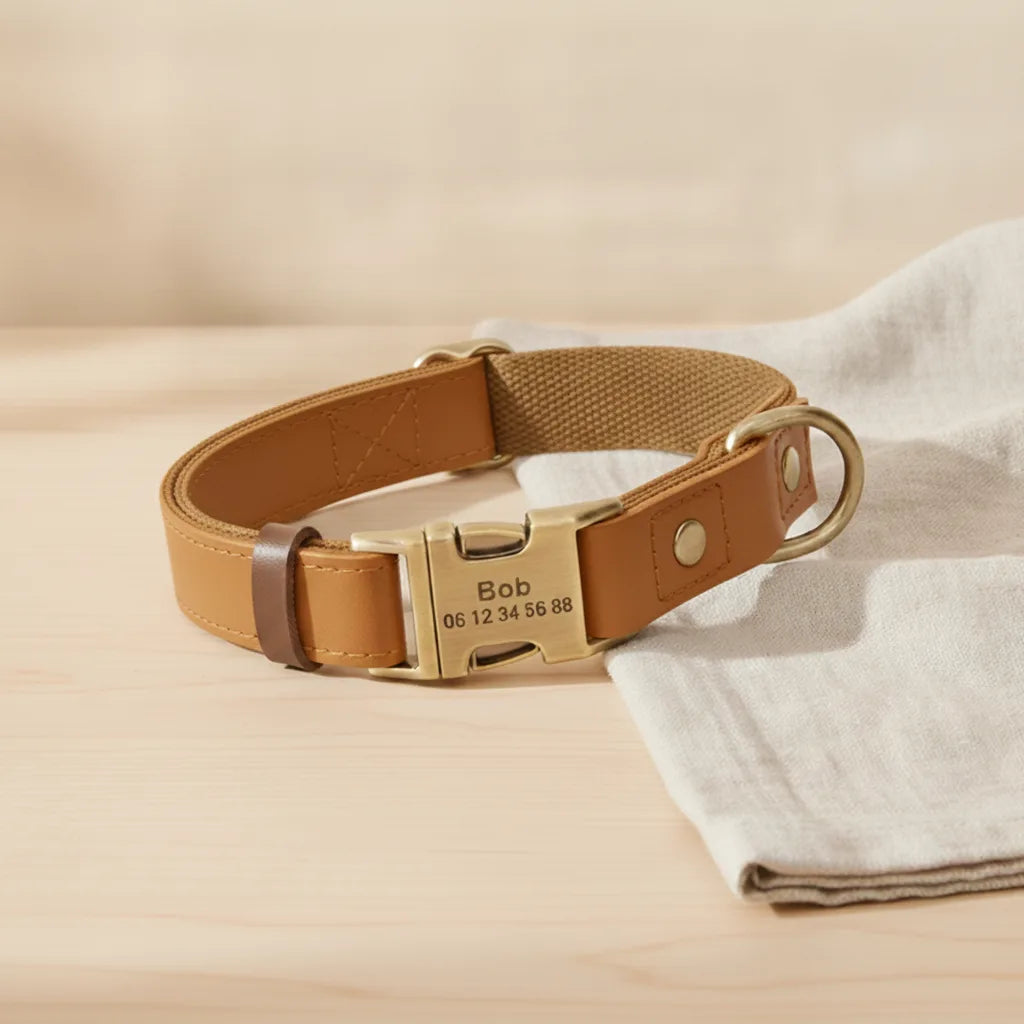 Collier pour chien en cuir marron personnalise avec plaque gravee, pose sur une table en bois