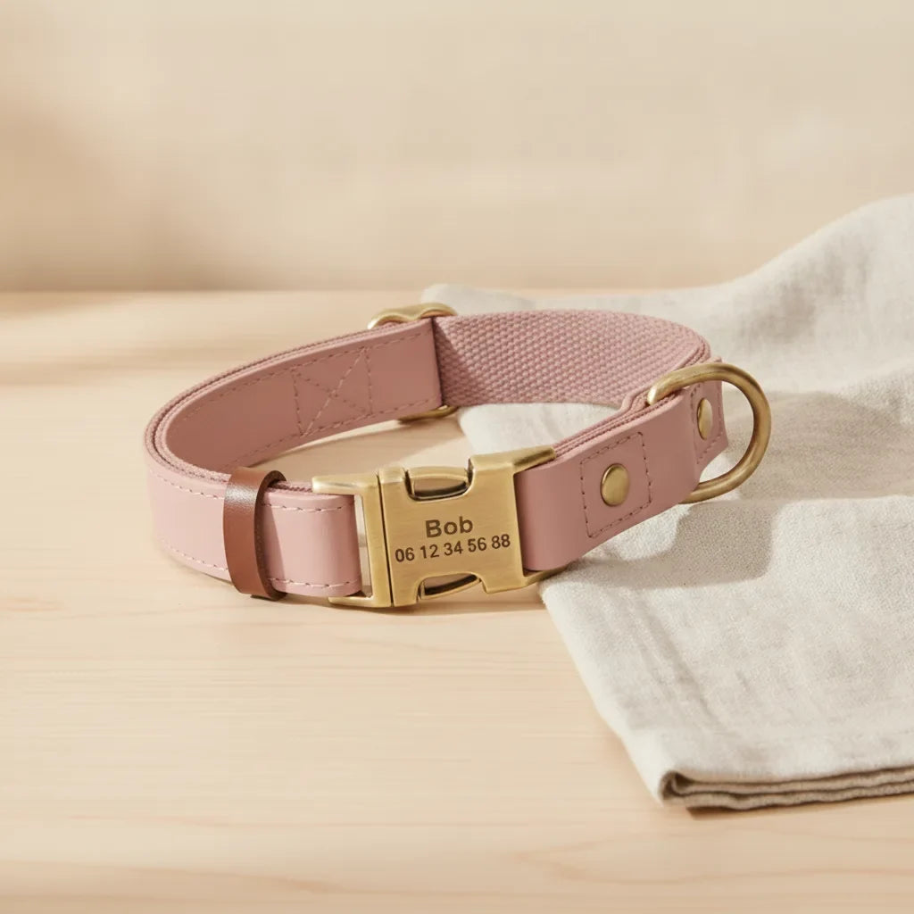 Collier pour chien en cuir rose personnalise avec plaque gravee, pose sur une table en bois