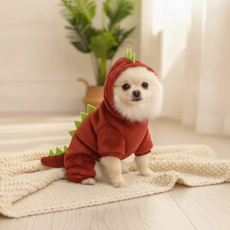 Chien Pomeranien portant une combinaison deguisement dinosaure rouge a capuche